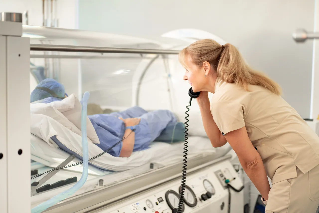 Clinic team member speaking with a patient inside a hyperbaric oxygen chamber